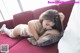 A woman laying on a red couch in a white lingerie.