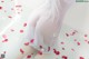 A woman in a white dress sitting in a bathtub with rose petals.
