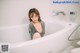 A woman sitting in a bathtub in a bathroom.