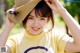 A woman in a yellow shirt and a straw hat.