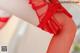 A close up of a woman's legs wearing red stockings.